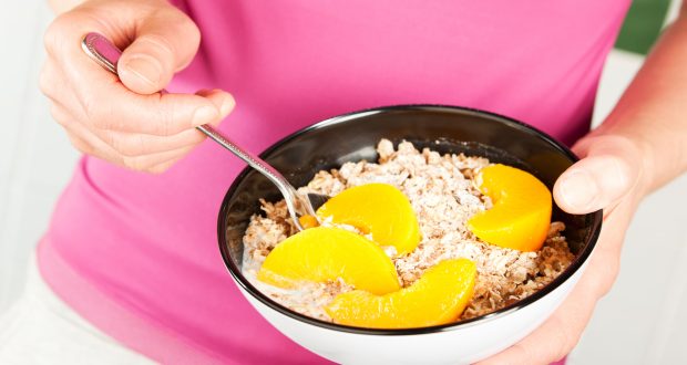 Bowl of breakfast oats with sliced peaches